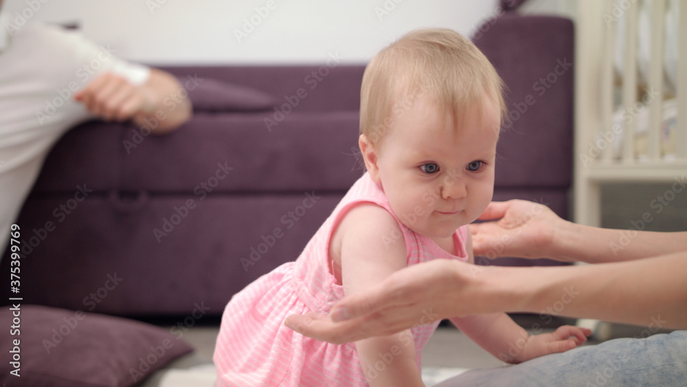 Adorable baby playing with father. Infant crawling to mom. Toddler girl crawl Adorable baby playing with father. Infant crawling to mom. Toddler girl crawl