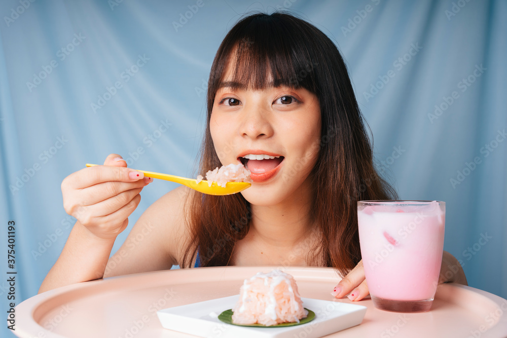 Close up of young asian woman eating sweet sticky rice with spoon. Close up of young asian woman eating sweet sticky rice with spoon.