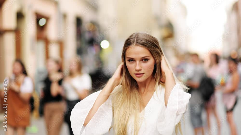 Girl turns around and looks into the camera. Beautiful woman with a magnificent golden hair