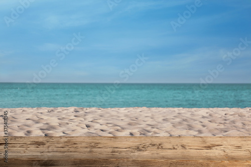Fototapeta Naklejka Na Ścianę i Meble -  Wooden surface on sandy beach near ocean