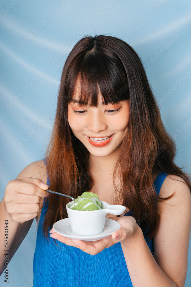 Asian dark hair woman eating sweet green sticky rice. Asian dark hair woman eating sweet green sticky rice.