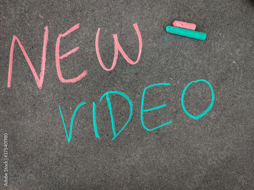 The inscription text on the grey board,NEW VIDEO. Using color chalk pieces.