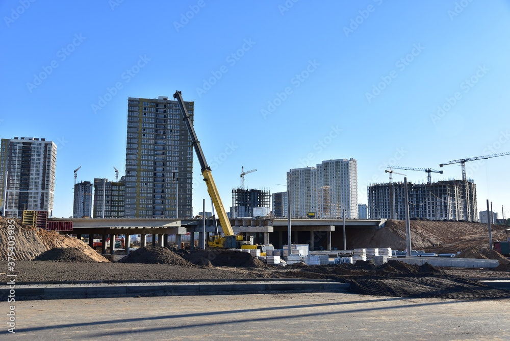 Work of truck crane on bridge project works. Roundabout traffic bridge construction and highway ramps. Road work on traffic highway, road intersection junction and freeway