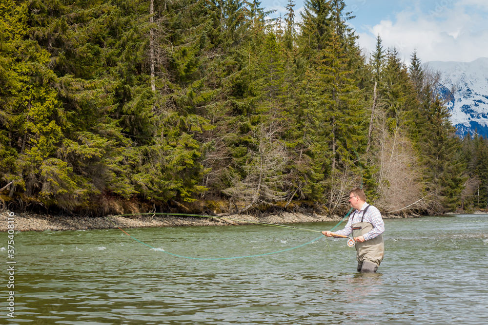 Close up of a fisherman spey casting on a river in British Columbia, Canada