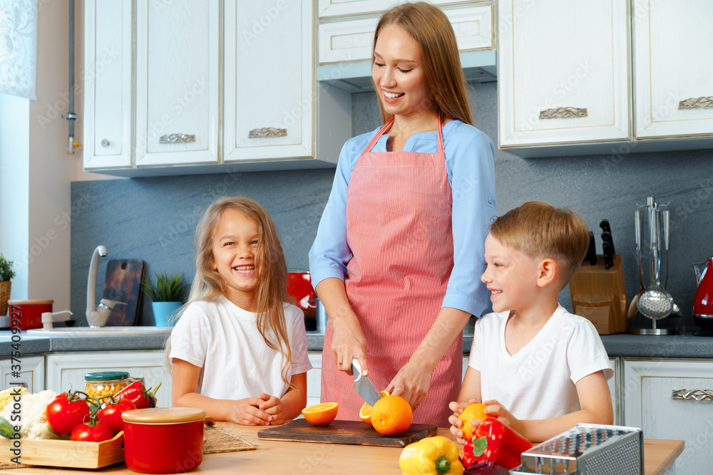 Mother cooking with her children in kitchen