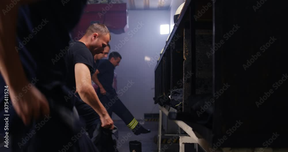 Firefighters putting on uniform near truck Firefighters putting on uniform near truck