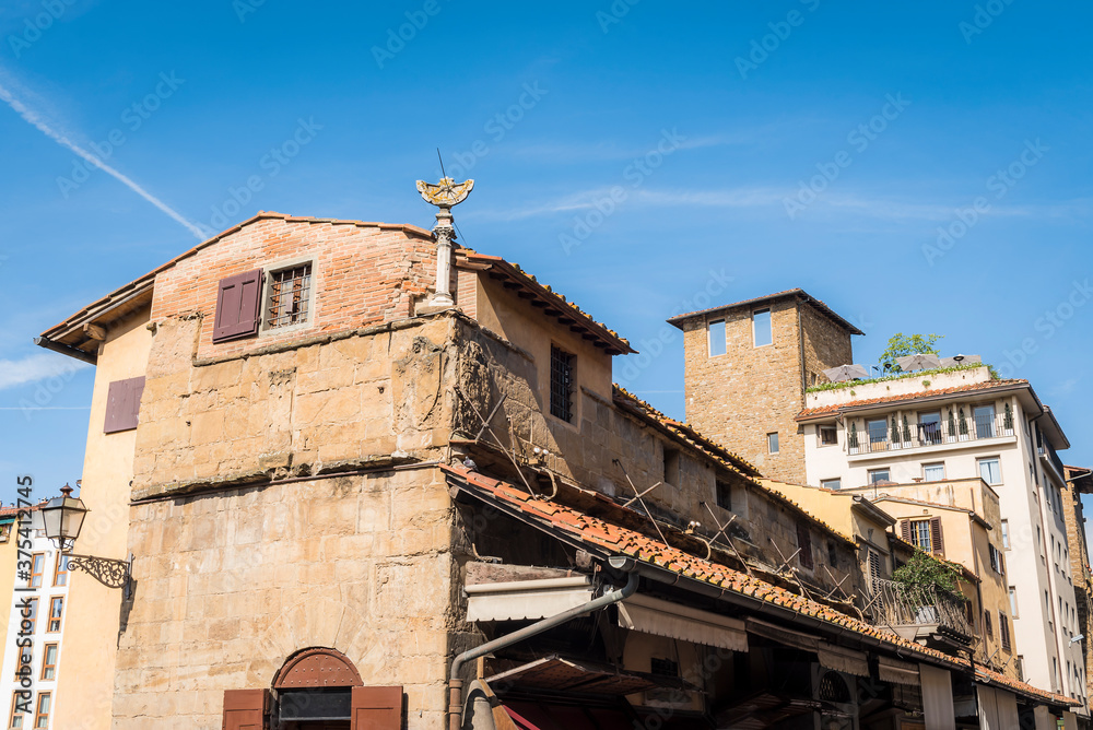 Old house with dilapidated sun clock and tower in Florence, Italy