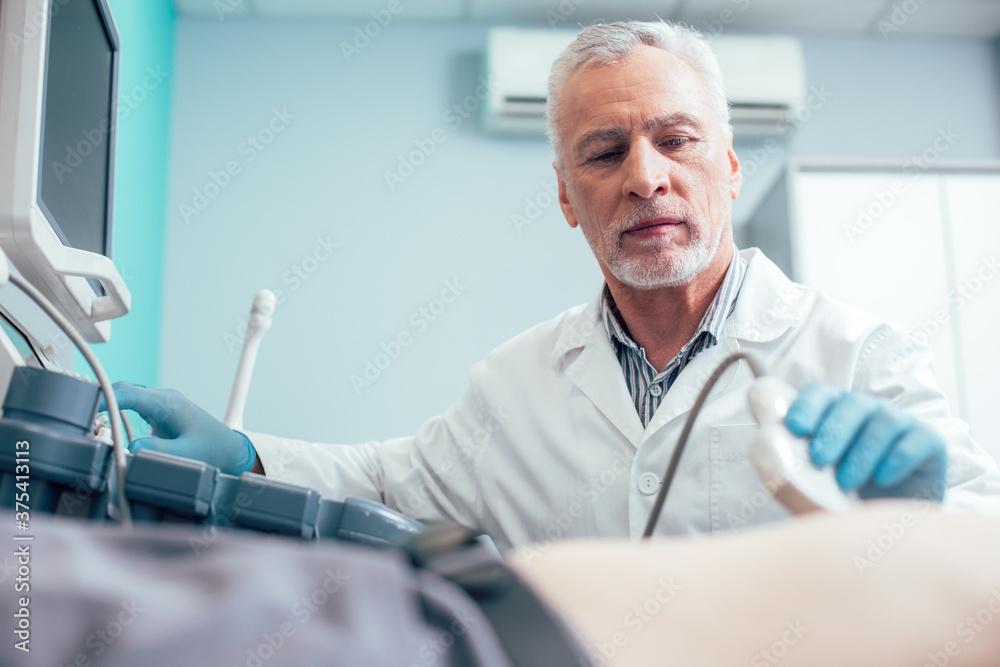 Obraz premium Smart Caucasian doctor working on ultrasound diagnostics