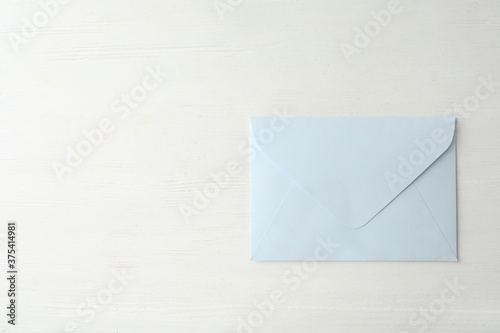 Light paper envelope on white wooden table, top view. Space for text