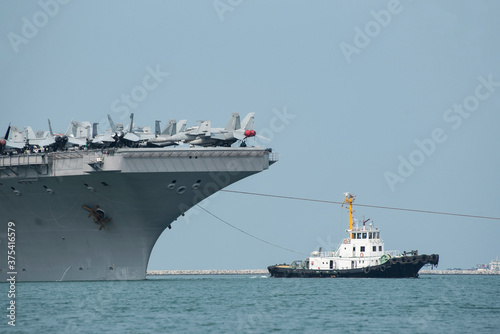 Military ship, captain deck with maritime control room and antenna and bridge deck with air plane on blue sky background.