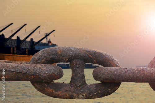 Close up of old rusty chain, industrial port with chainss, crane background out of focus, sunny day, industrial concept photo