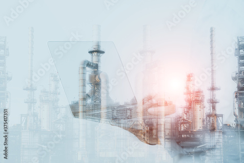 Double exposure workers on computer note book on oil refinery plant