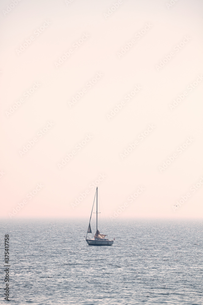 Sailing sailboat on a foggy day, color toning applied.