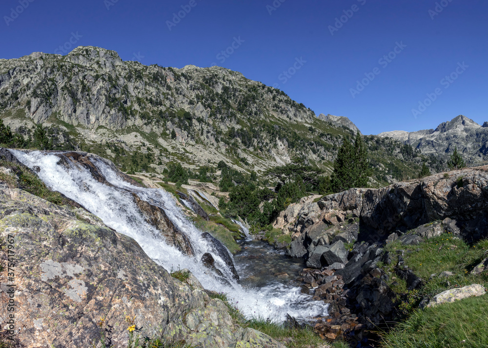 Waterfall in high mountains at Marcadau valley, Pyrenees National Park, department of Hautes-Pyrenees, France Waterfall in high mountains at Marcadau valley, Pyrenees National Park, department of Hautes-Pyrenees, France
