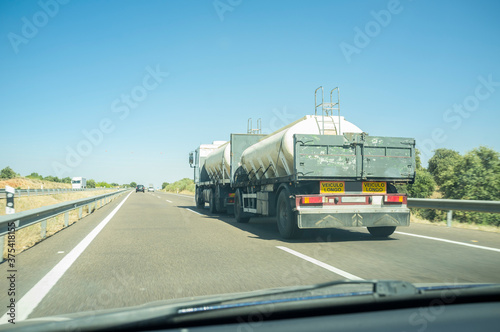 Driving behind B-double trailer loading tanks on divided highway road