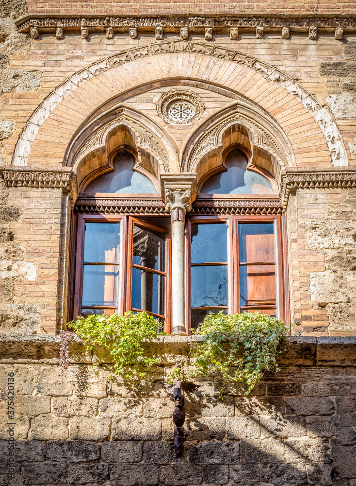 Window with a column in the Venetian style in a medieval building in San Gimignano, Italy