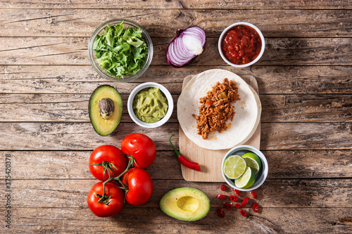 Mexican tacos ingredients on wooden table