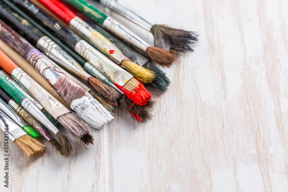 Fototapeta premium Artist vintage paint brushes on white wooden background