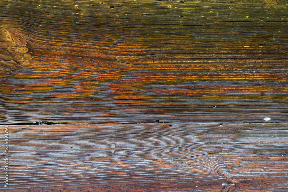 Fototapeta premium Sunburnt wood, aged by wind and time. Old wood texture. Weathered cut of tree rings.