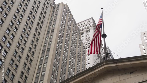 American National Flag Waving on a Pole Under Skyscrapers of Manhattan, New York USA. Slow Motion