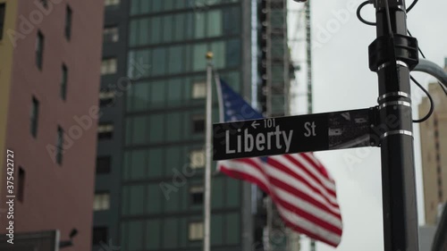 Manhattan, New York. Liberty Street Sign With American Flag Waving in Background Detail Slow Motion