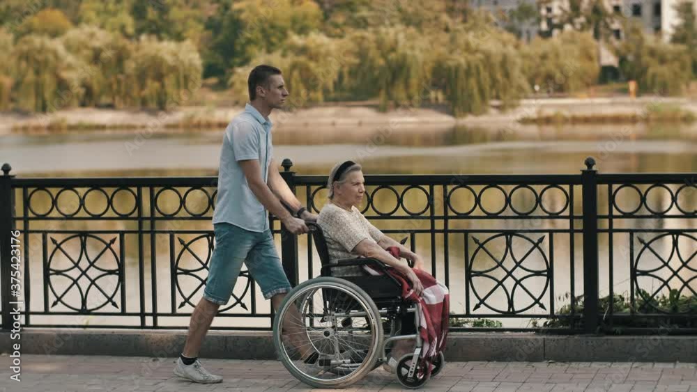 Man pushing senior woman on a wheelchair Man pushing senior woman on a wheelchair