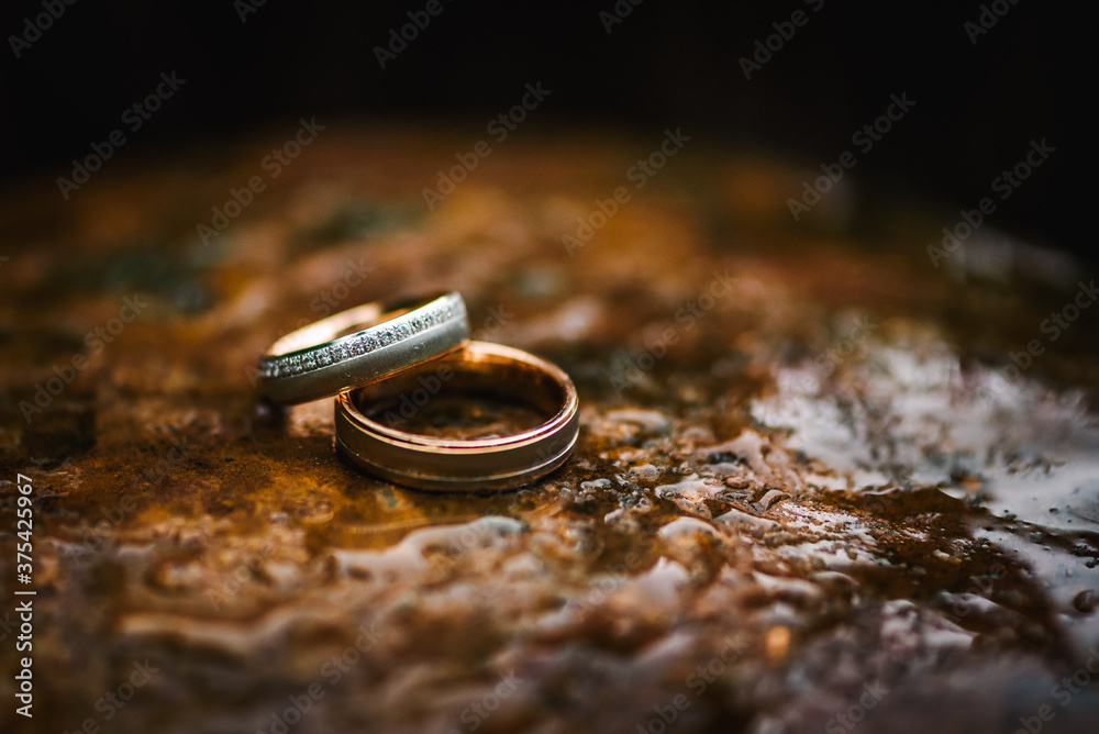 Wedding rings on a table with water drops on it Wedding rings on a table with water drops on it