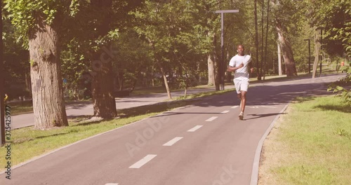 Wallpaper Mural Sporty african american guy running in empty morning park alone, listening to music Torontodigital.ca