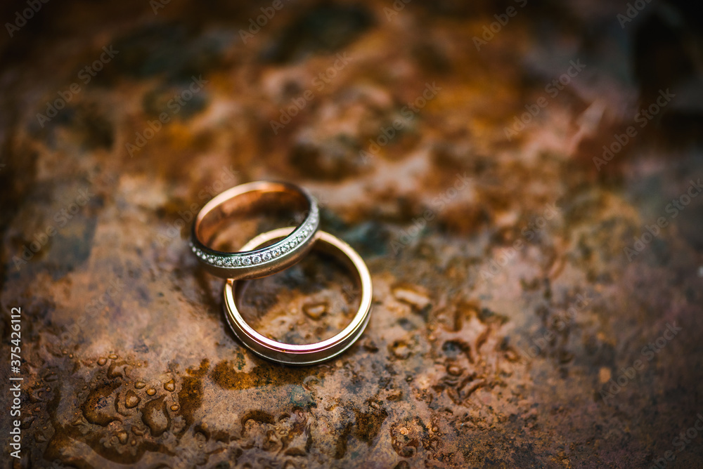 Wedding rings on a table with water drops on it Wedding rings on a table with water drops on it
