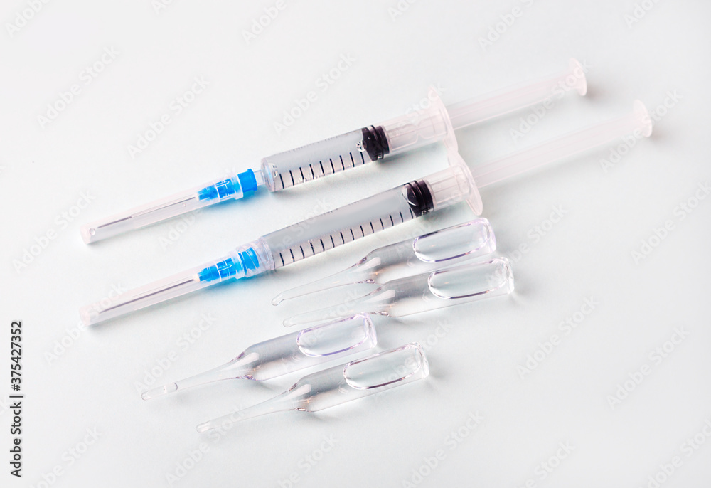 Fototapeta premium Medical concept with a syringe and covid-19 vaccine ampoule.