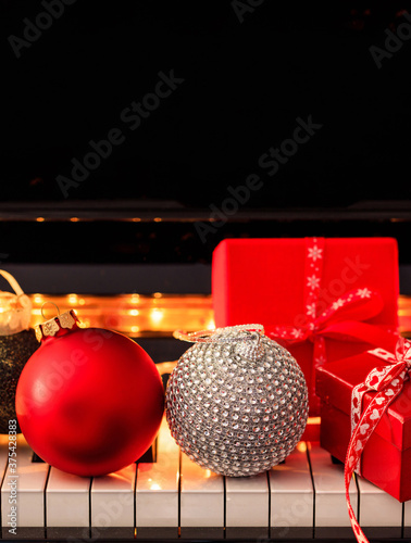 Photography Chritmas balls and gifts on piano keyboard. Xmas music, songs