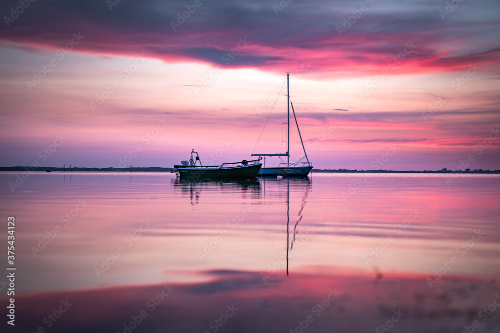 sailing boats in the pink lake at sunset