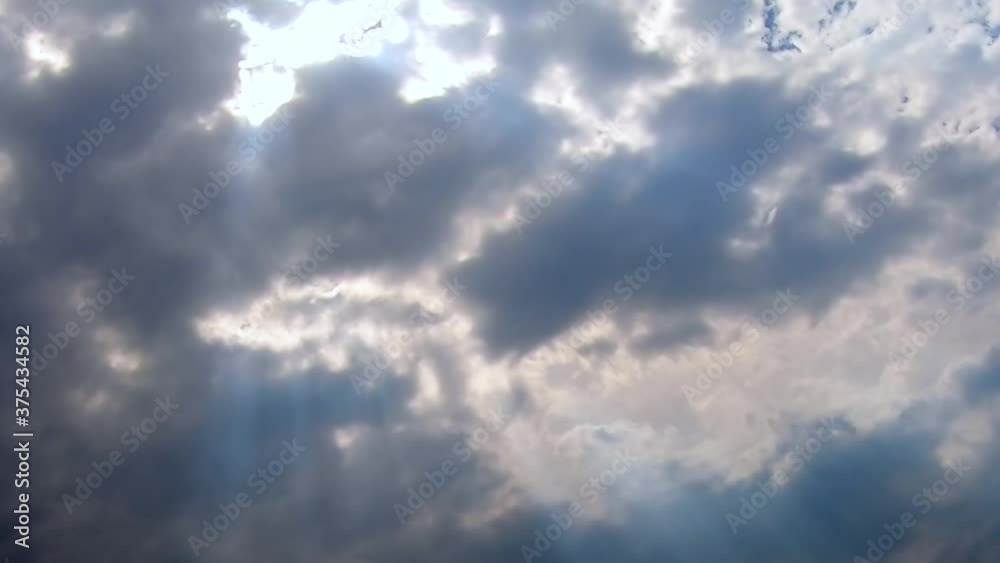 Fluffy cloud sky above with sun rays shinning through , summer day Fluffy cloud sky above with sun rays shinning through , summer day