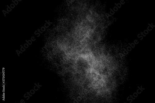 Abstract splashes of water on black background. Freeze motion of white particles. Rain, snow overlay texture.