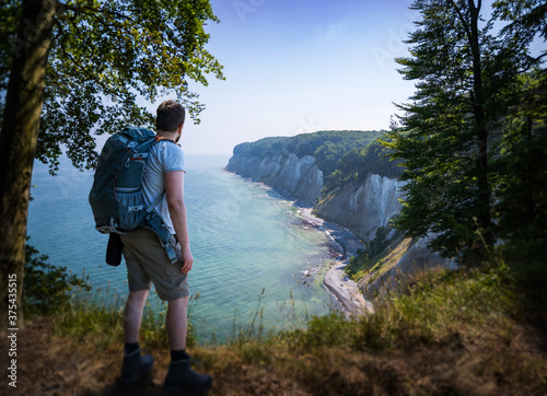 person with a backpack gazing at the chalk cliffs of rügen