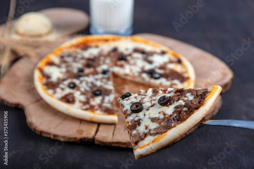 Meat Italian pizza with roast beef, steak slices, melted cheese, with olive slices and cheddar cheese. Close up, macro. Pizza time concept. Turkish name; Kavurmali Pizza photo