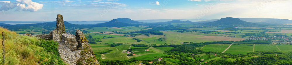 Panoramic photo of lake Balaton and the Badacsony mountains with the Kali basin from the mountain top of Csobanc with castle ruins in the foreground Panoramic photo of lake Balaton and the Badacsony mountains with the Kali basin from the mountain top of Csobanc with castle ruins in the foreground