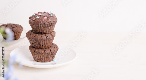 Chocolate biscuit muffins on white plate with copy space