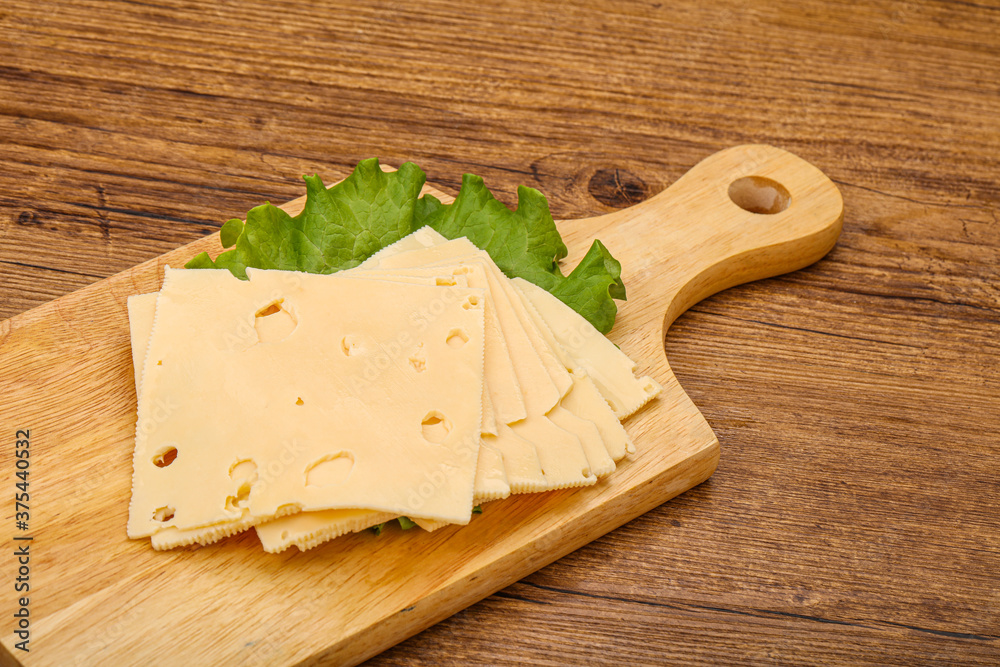 Sliced yellow cheese over board