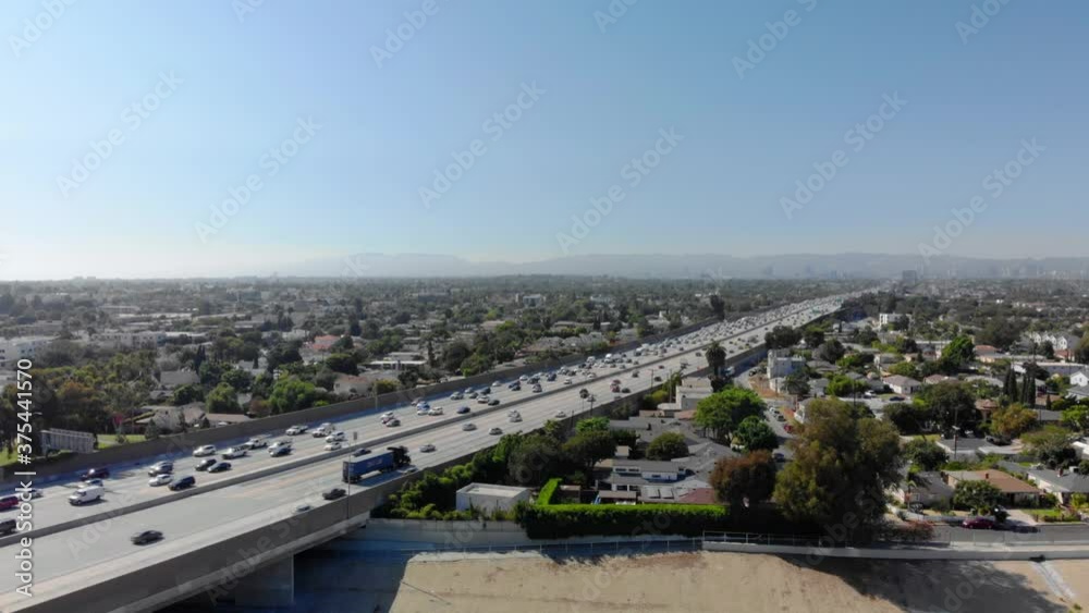 Aerial flying over LA river overlooking traffic on Interstate 405 with mountains in the background, the San Diego freeway, bright, sunny day, in Los Angeles, California, USA - drone shot Aerial flying over LA river overlooking traffic on Interstate 405 with mountains in the background, the San Diego freeway, bright, sunny day, in Los Angeles, California, USA - drone shot