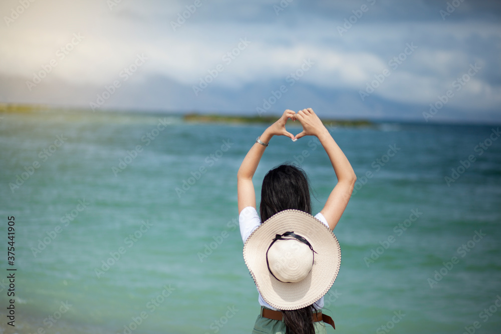 Fototapeta premium woman hand heart sign in sea