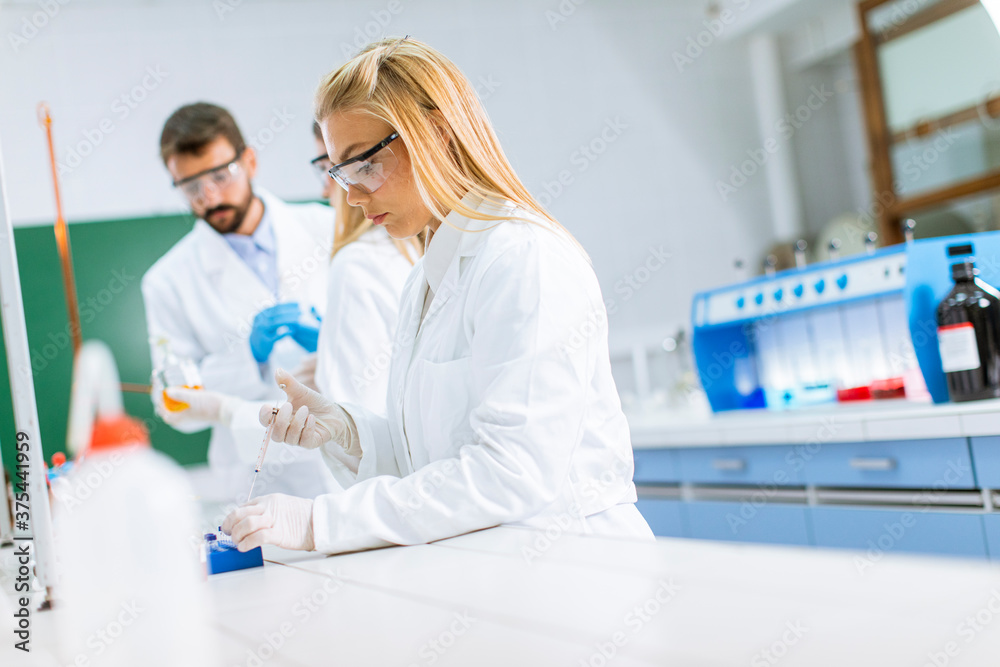 Group of young researchers analyzing chemical data in the laboratory Group of young researchers analyzing chemical data in the laboratory