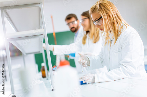 Group of young researchers analyzing chemical data in the laboratory