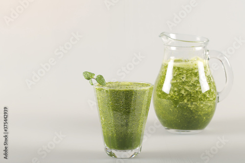 a green smoothie is on the table next to healthy foods photo