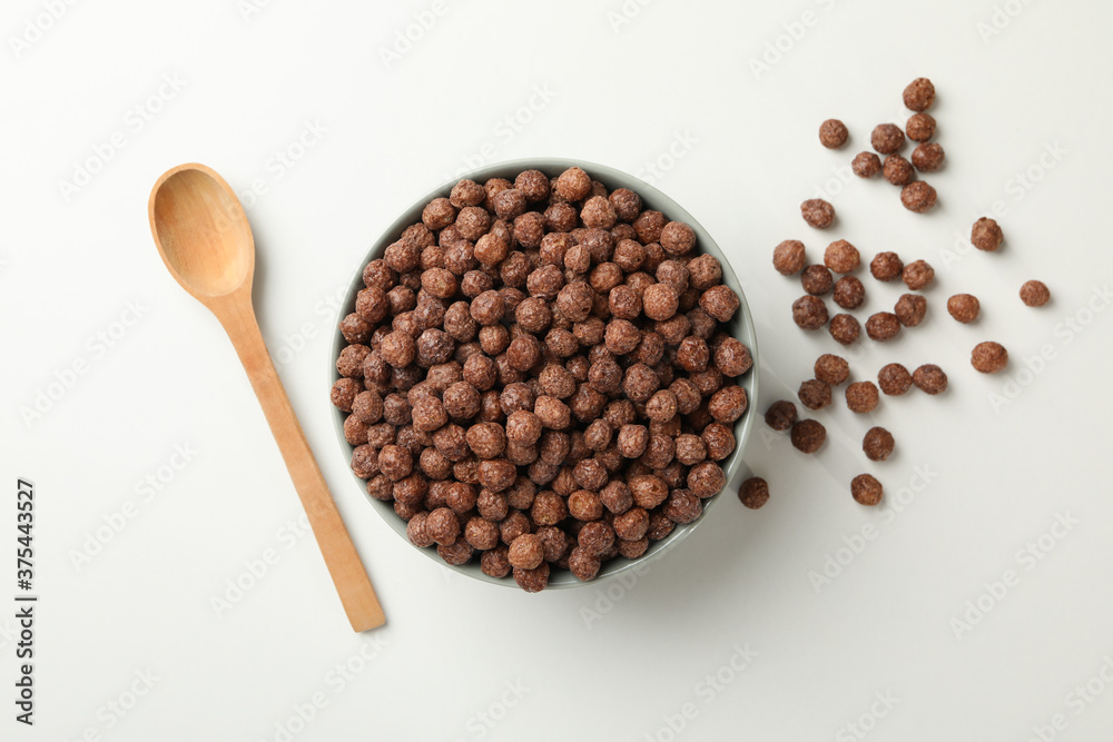 Spoon and bowl with corn balls on white background, top view Spoon and bowl with corn balls on white background, top view