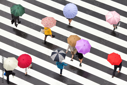 People with colorful umbrellas crossing a street in Shibuya, Tokyo, Japan photo