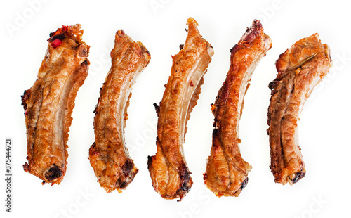 Sliced baked pork ribs on a white plate, isolate