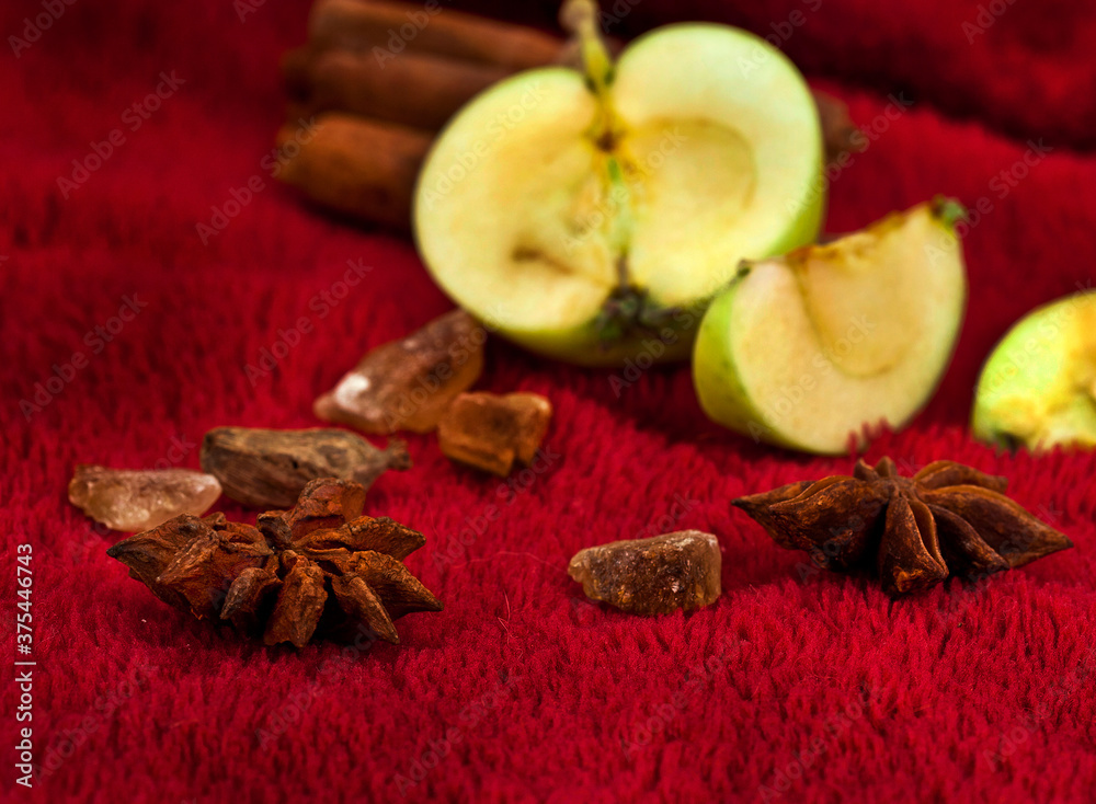 Star anise, brown sugar and apples on a red textile background. Autumn and winter holidays concept. Star anise, brown sugar and apples on a red textile background. Autumn and winter holidays concept.