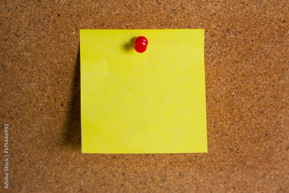 yellow note paper on cork board wtih push pin yellow note paper on cork board wtih push pin