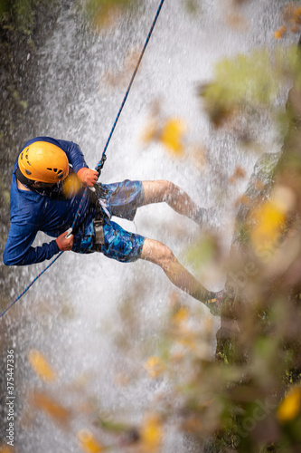 Amateur Man rappelling down a waterfall photo